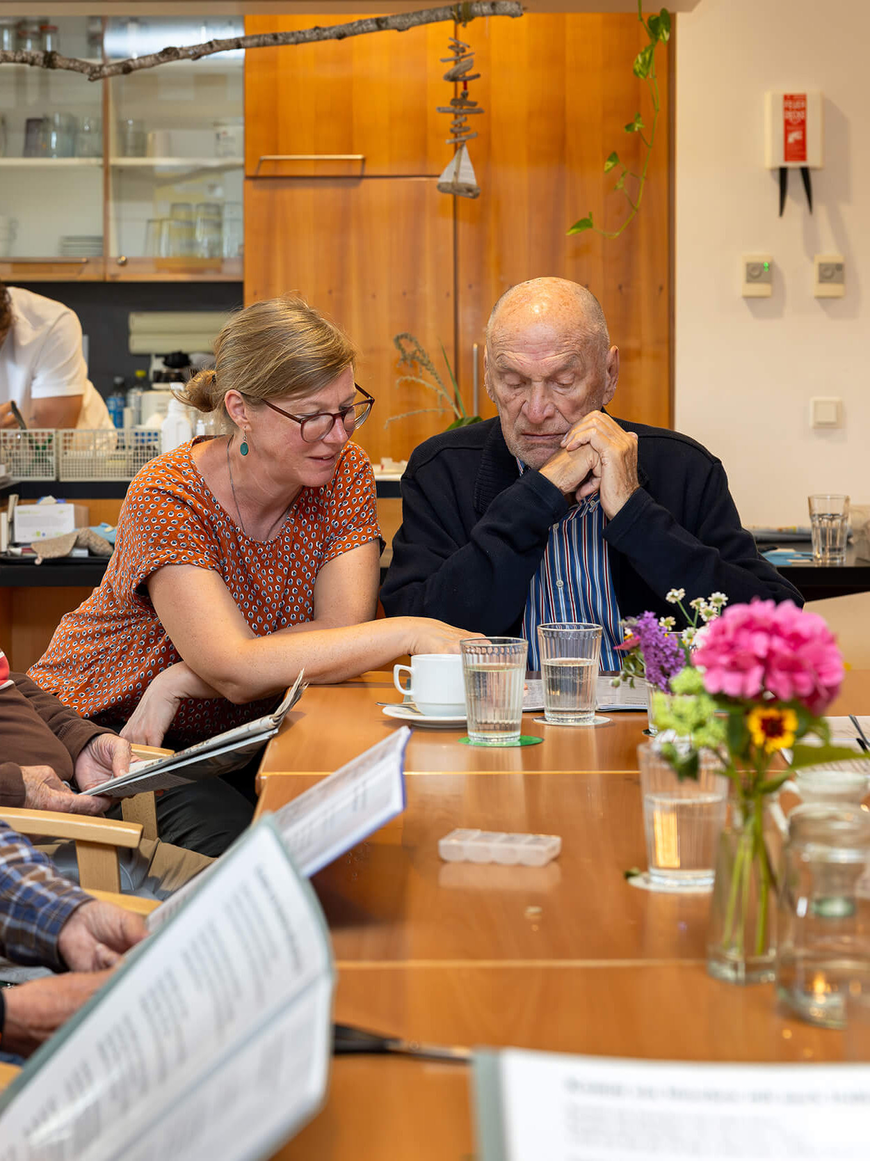 Menschen sitzen an einem Tisch und singen